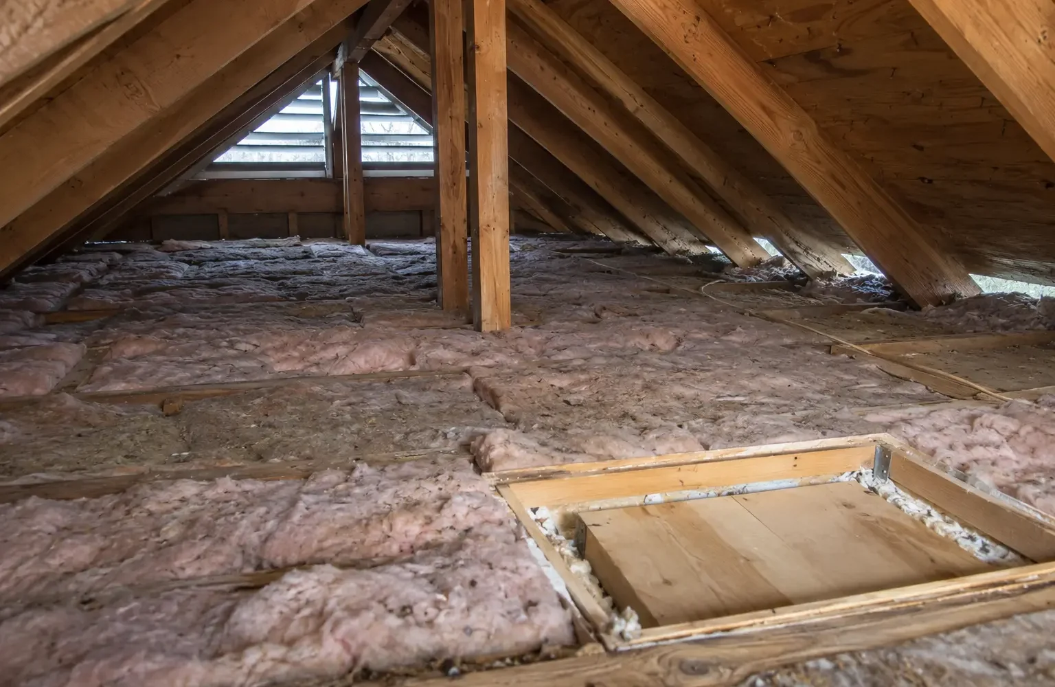 Old compressed attic insulation with thin areas near the eaves